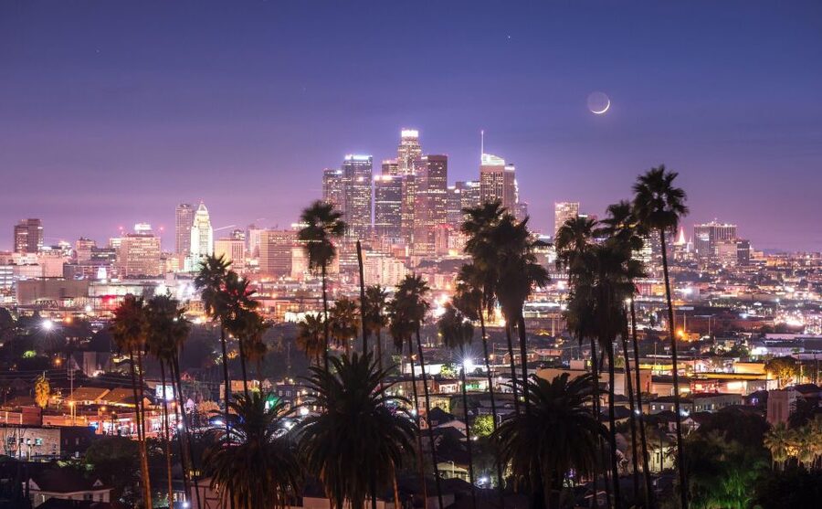 The downtown Los Angeles skyline at dusk, seen over the palms from Griffith Park